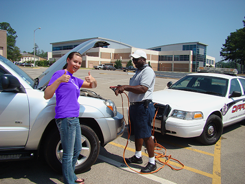 UPD officer helping jump-start a student's vehicle.